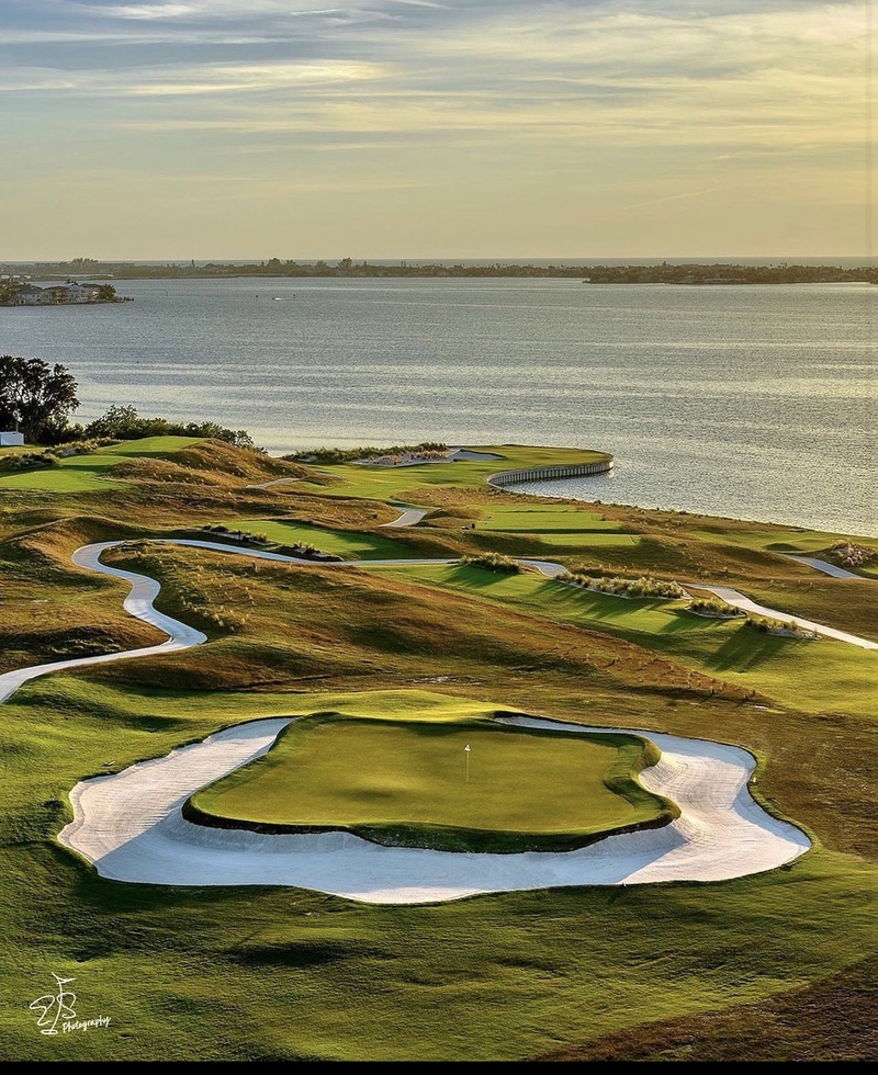 A waterfront golf course in warm evening light